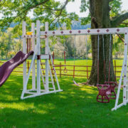 This image shows a red and ivory swing set