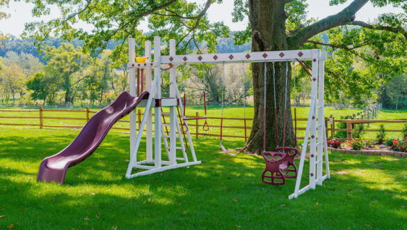 This image shows a red and ivory swing set