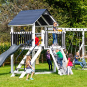 This image shows a white and black swing set with children playing on it