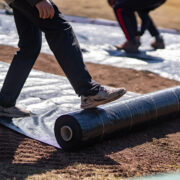 This image shows our crews rolling out weed guard for a swing set play area