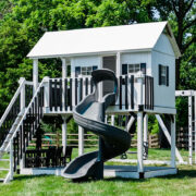 This image shows a white playhouse with a gray slide staircase and swing beam