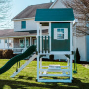 This image shows a green playhouse with a green slide