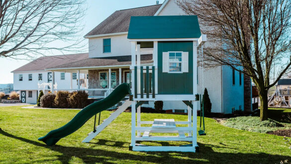 This image shows a green playhouse with a green slide