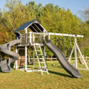 A swing set by King Swings is sitting in a field of grass