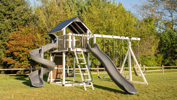 A swing set by King Swings is sitting in a field of grass