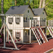 This image shows a large ivory playhouse with lots of fun slides climbers and more