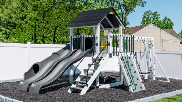 This image shows a swing set with three slides, rock wall, and staircase from King Swings.