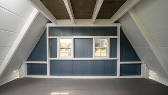 Interior view of an A frame playhouse with walls windows and open play space