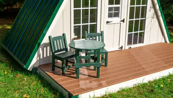 This image shows the porch and tea table and chairs that come with the Summit A-frame playhouse from King Swings.