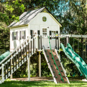 This image shows an ivory and green playhouse from King Swings