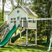 This image shows an ivory and green playhouse from King Swings