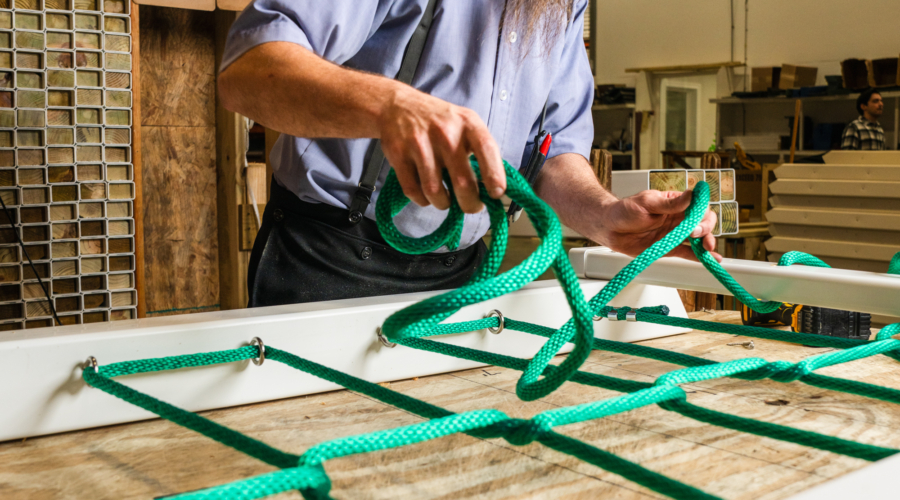 This image shows one of our hardworking Amish craftsmen building a cargo net climber.