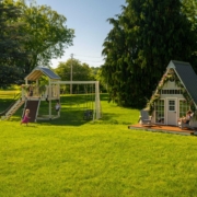 Two swing sets are sitting in a grassy field